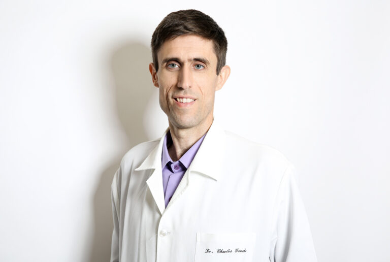 Dr. Charles, especialista em dermatologia, explicando o funcionamento do método de tratamento de acne integrado em seu consultório.